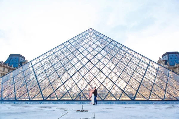 Hermosa pareja enamorada cerca del edificio del Museo del Louvre en París . — Foto de Stock