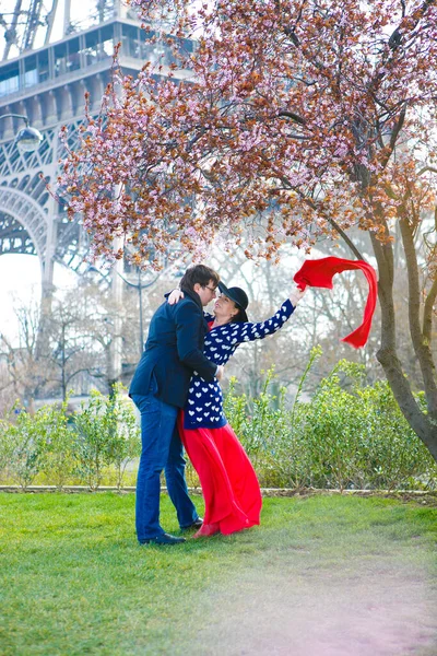 Hombre y mujer en la calle de la primavera París, en la parte posterior del árbol de flores, Torre Eiffel — Foto de Stock