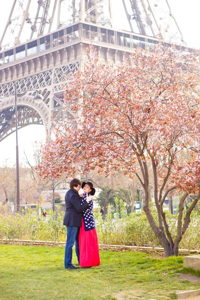 Hombre y mujer en la calle de la primavera París, en la parte posterior del árbol de flores, Torre Eiffel — Foto de Stock