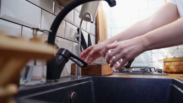 Ισοζύγιο νερού. χέρι να πάρει καθαρό νερό στο γυαλί. καθαρισμός πόσιμο νερό στο σπίτι. — Αρχείο Βίντεο