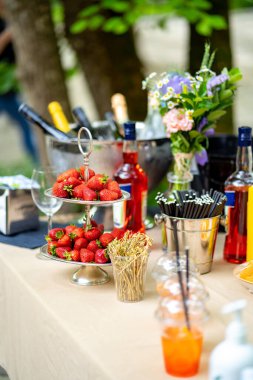Yemek servisi. Çilekli açık hava masası, içecekler, çiçekler. Açık büfe.