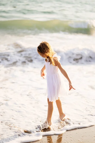 Девушка прогулки и развлечения на берегу моря с большими волнами и сильными ветрами . — стоковое фото