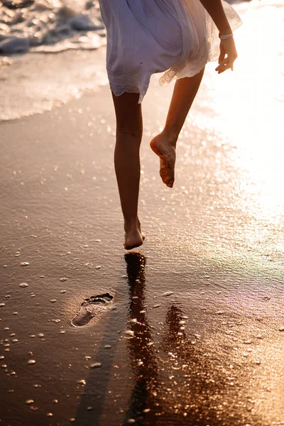 little feet leave footprints on sandy shore of sea. walks on beach.