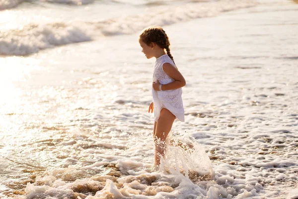 Passeggiate bambina e divertimento sulla riva del mare con grandi onde e forti venti . — Foto Stock