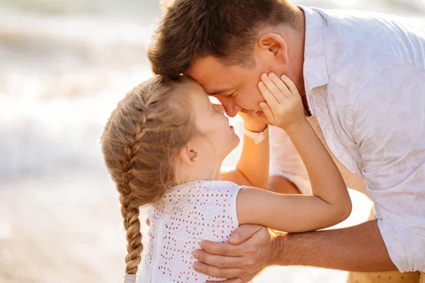 Un beso. padre con hija caminando a lo largo de la orilla del mar en tiempo ventoso. familia divertida . —  Fotos de Stock