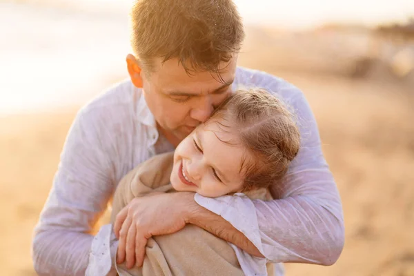 dad wipes, warms daughter after swimming in sea in dresses. kid in wet clothe