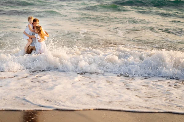 Molhado pai e filhas nadando no mar em roupas, brincando e se divertindo . — Fotografia de Stock