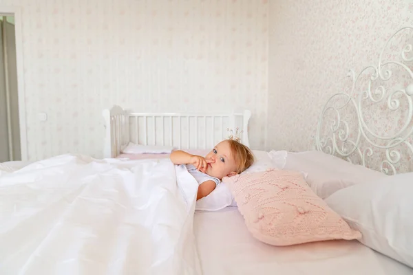 어린 소녀는 왕관을 쓰고 침실에서 자고 있었다. 공주 생일 파티. — 스톡 사진