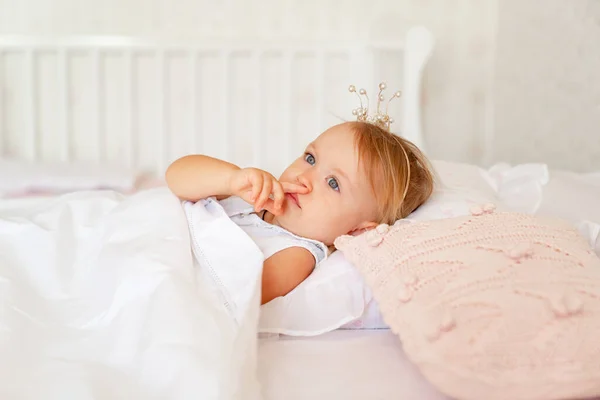 Niña durmiendo en la cama en el dormitorio con corona. Fiesta de cumpleaños princesa . — Foto de Stock
