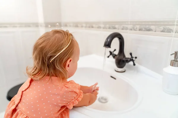 Niña en corona, se lava las manos en el baño. higiene y limpieza . — Foto de Stock