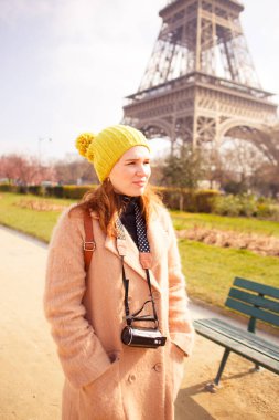 Paltolu ve şapkalı bir kadın, Paris 'te bahar yürüyüşü yapıyor..