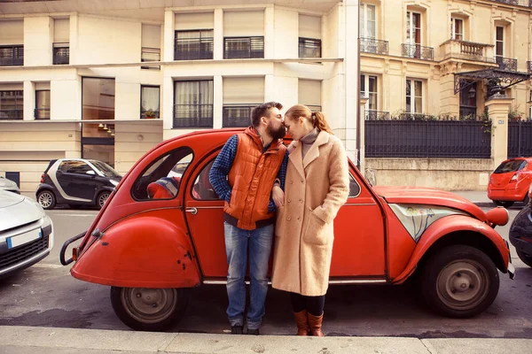 Pareja hombre y mujer de pie en rojo coche retro, caminando en la primavera París . — Foto de Stock