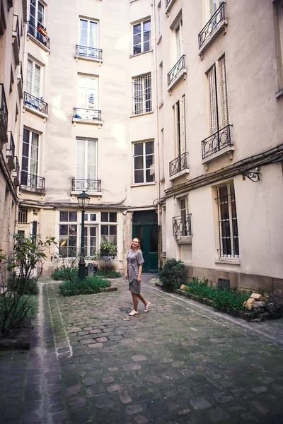 Femme en robe grise debout dans la cour de la maison des villes européennes . — Photo