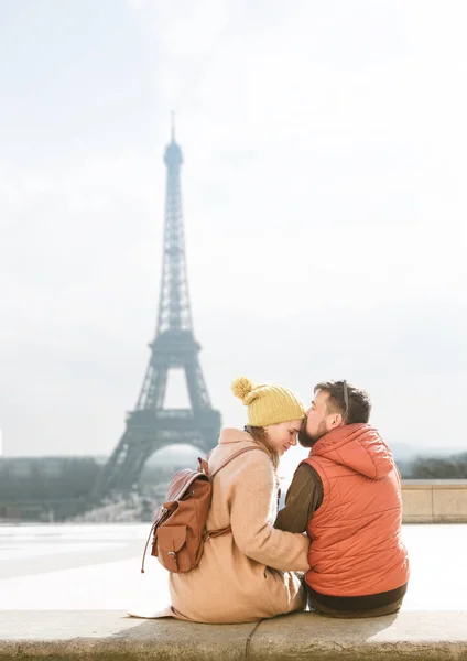 Visão traseira. turistas, homem e mulher sentados em frente à torre Eiffel . — Fotografia de Stock