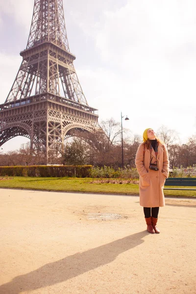 Γυναίκα με παλτό και καπέλο με βιντεοκάμερα περπατά την άνοιξη στο Παρίσι. — Φωτογραφία Αρχείου