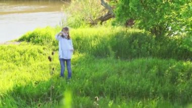 Küçük kız piknikte sabun köpüğü şişiriyor.