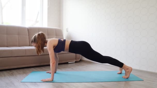 Chica se dedica a los deportes en casa, haciendo push-UPS. hermoso cuerpo sexy . — Vídeo de stock