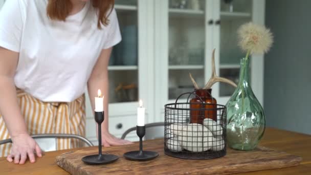 Mujer sopla velas en la mesa de la cocina después de la cena familiar . — Vídeos de Stock