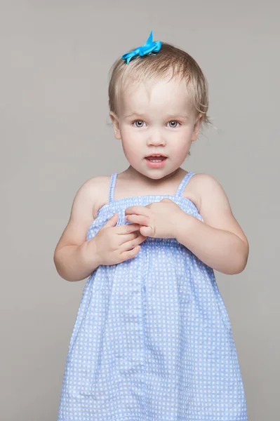 Kleines Mädchen in blauem Kleid mit kurzen Haaren und Schleife. Glückliche Kindheit. — Stockfoto