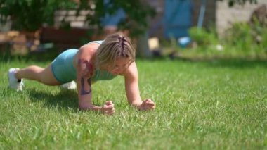 Kız çimenlikte leke sürüyor. Tahta egzersizi. çocuk doğduktan sonra iyileşme.