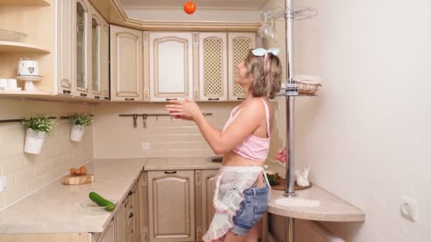 Sexy blondýny hospodyňka žonglování pomeranče na kuchyni. — Stock video