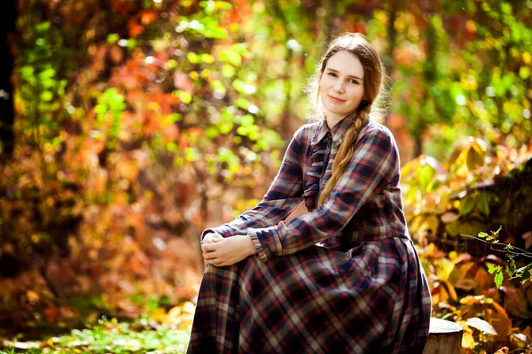 Donna in abito scozzese nella foresta autunnale. passeggiate nella natura. — Foto Stock