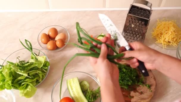Mãos femininas cortando verdes e cebolas para salada. preparação de alimentos saudáveis . — Vídeo de Stock