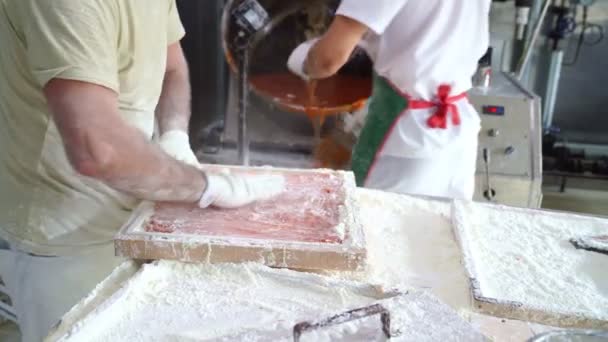 Gebaksfabrieksarbeiders voor marmelade of karamel op rollen. — Stockvideo