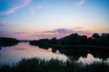 Güzel bir akşam manzarası. Nehirde gün batımı. Göldeki sakin su.