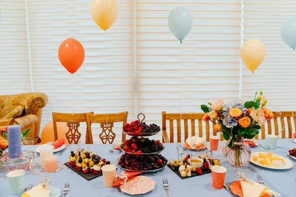 festive table at summer children\'s party in country house. decoration balloons.