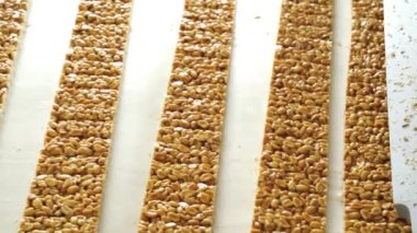 Şekerleme fabrikası. Endüstriyel taşıma hattında uzun çubuklar fıstık ezmesi şekeri.