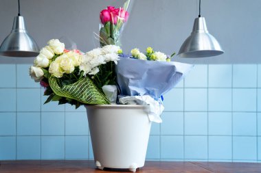 Beyaz kovada buketler. Restoranda verilen şölende bağışlanan çiçeklerin saklanması.