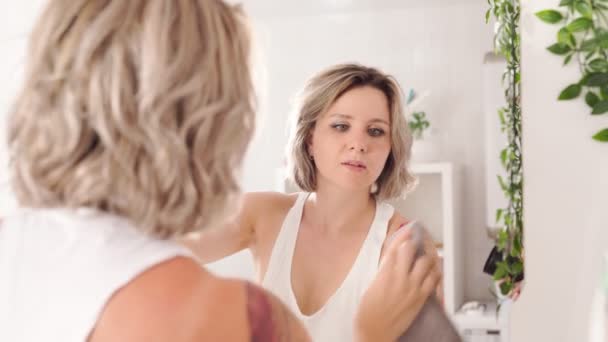 Сексуальна жінка з татуюваннями робить прибирання, миє дзеркало вдома — стокове відео