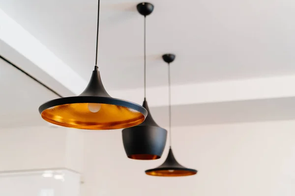 Lámpara de araña de cobre pintado de negro en el techo. iluminación en el interior . — Foto de Stock