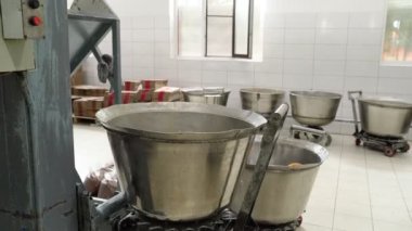 Halva pişirmek için kütle kabını kaldırır ve taşıyıcı bandın üzerine dökülür..
