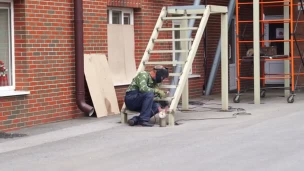 Svářeč muž v brýlích dělá svařování kovové schodiště. — Stock video