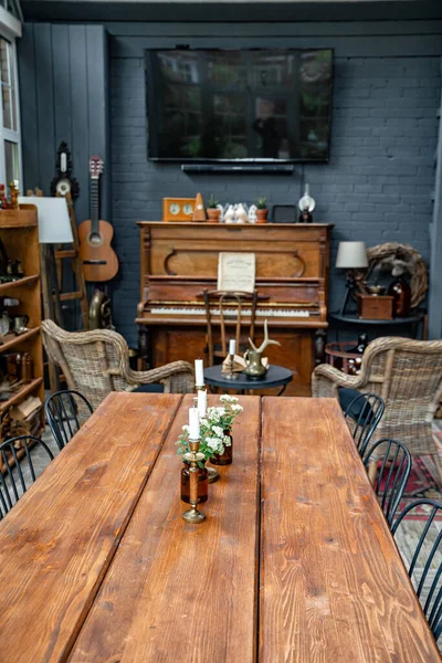 Stół ze świecami i kwiatami w pokoju z fortepianem. wnętrze w stylu retro. — Zdjęcie stockowe