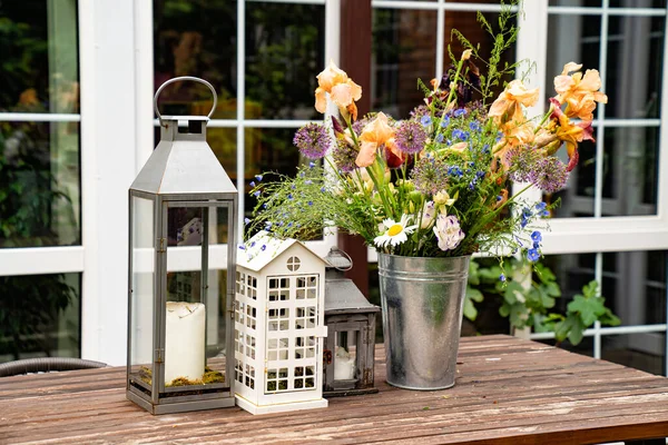 Mesa no jardim da casa de campo. castiçais e buquê de flores . — Fotografia de Stock