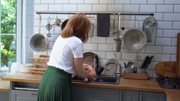 Жінка миє скло і п'є воду в нього і простягає руку вперед . — стокове відео