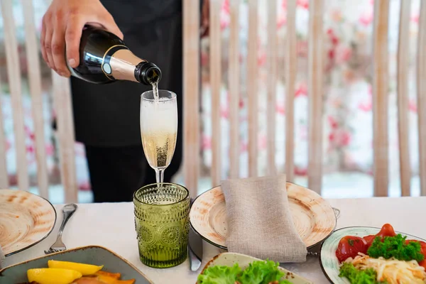 Em copo despeje champanhe. catering para mesa festiva . — Fotografia de Stock