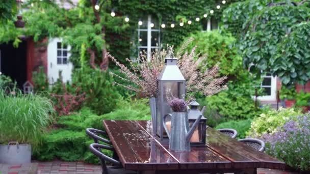 Tuin in de regen in de zomer. boeket gedroogde bloemen op tafel. — Stockvideo