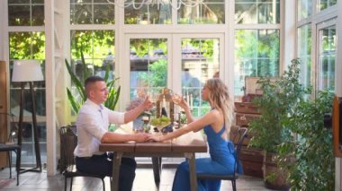 Çiftler için romantik bir yemek. Aşıklar kadehten şarap içer.