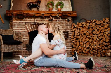 Aşıklar şöminenin önünde halıda oturuyor.. 