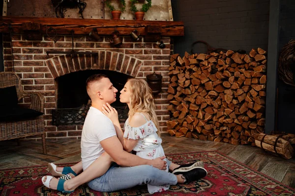 Lovers are sitting on carpet in front of fireplace. close up. — Stock Photo, Image
