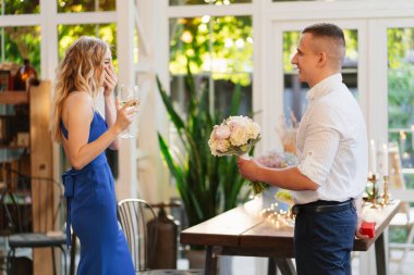 Adam el ve kupa teklif ediyor. Nişan yüzüğünü kız arkadaşına veriyor..