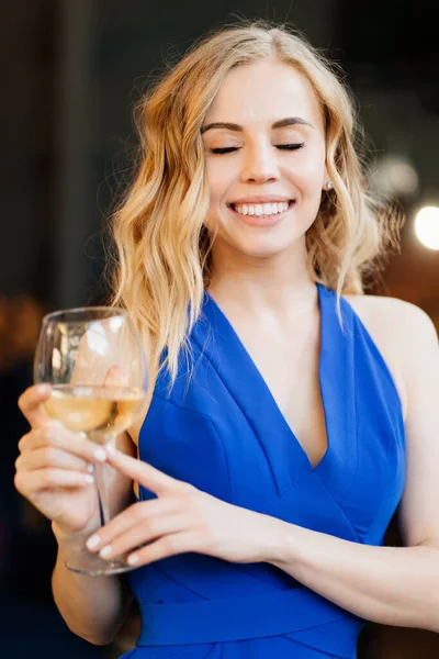 Menina em vestido azul de pé com copo de vinho . — Fotografia de Stock