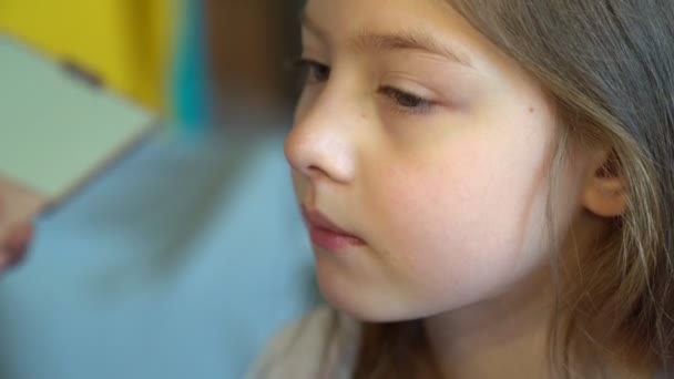 Close-up. little girl doing makeup, apply powder on face. — Stock Video