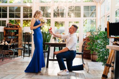 Adam el ve kupa teklif ediyor. Nişan yüzüğünü kız arkadaşına veriyor..