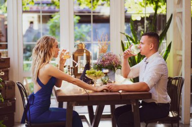 Çiftler için romantik bir yemek. Aşıklar kadehten şarap içer.