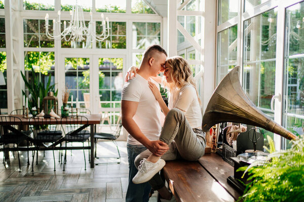 lovers beside ancient gramophone in sunlight from Windows. high key lighting